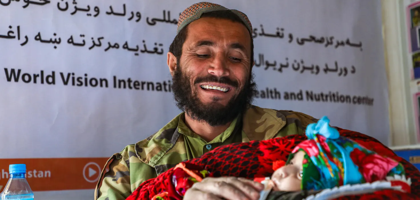 Ein afghanischer Vater zeigt stolz sein Baby bei einer Gesundheitsberatung von World Vision