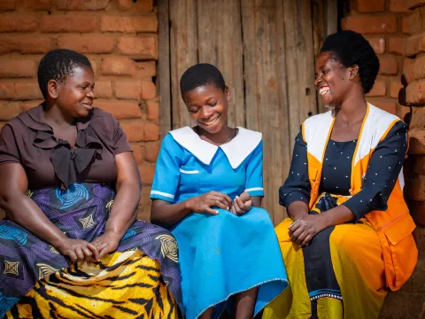 World Vision Mitarbeiterin mit zwei jungen Frauen in Malawi