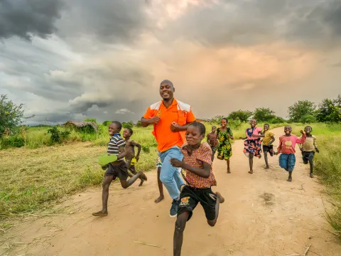 World Vision Mitarbeiter in Malawi spielt mit Kinder
