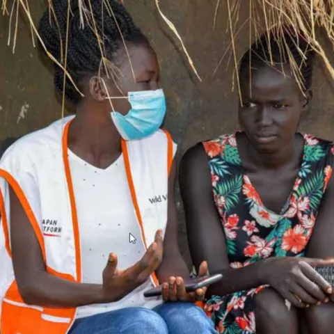 Elizabeth, a 19-year-old South Sudanese refugee who cares for her nine siblings, speaks with a World Vision staff member
