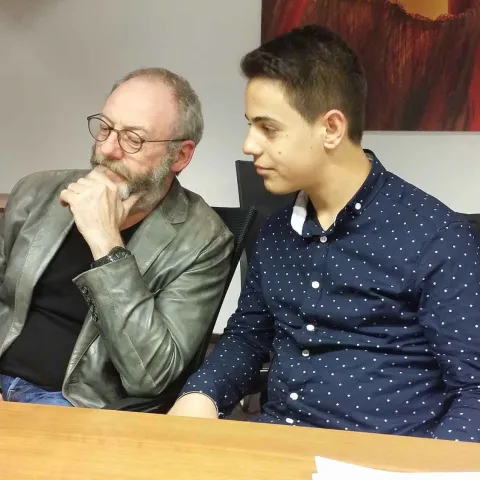 Liam Cunningham und Hussam aus Syrien sitzen zusammen World Vision