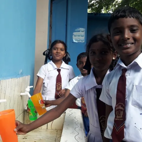 Kinder holen sich in der Schule sauberes Wasser