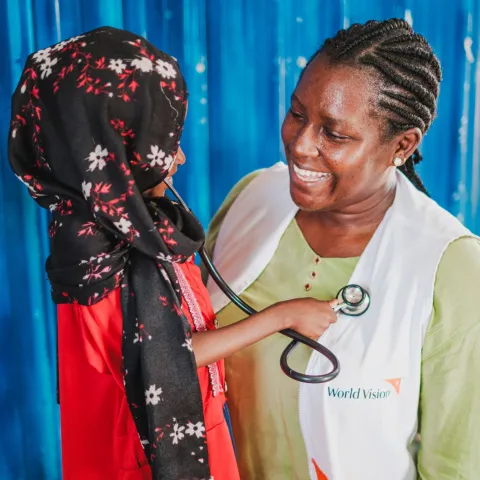 in geflüchtetes Mädchen aus dem Sudan spielt Ärztin mit Hebamme Paula Atimango.