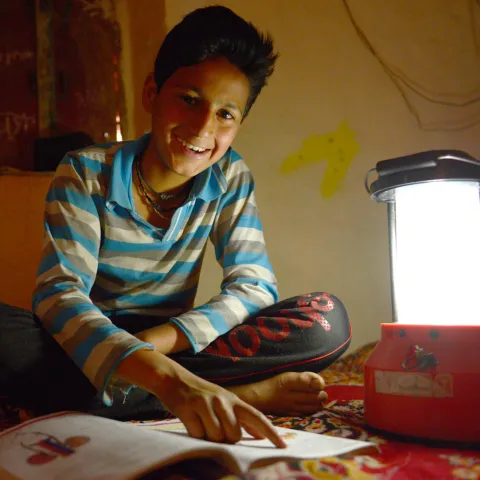 Junge mit Solarlampe aus Indien