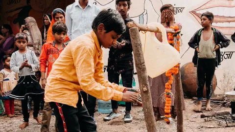 Junge in Indien wäscht seine Hände